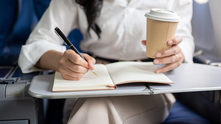 woman-traveling-pen-notebook-plane.jpg