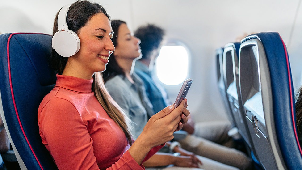 woman-looking-at-phone-on-airplane.jpg
