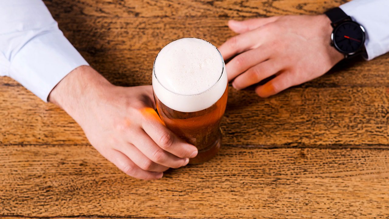businessman-holding-beer-mug-on-counter.jpg