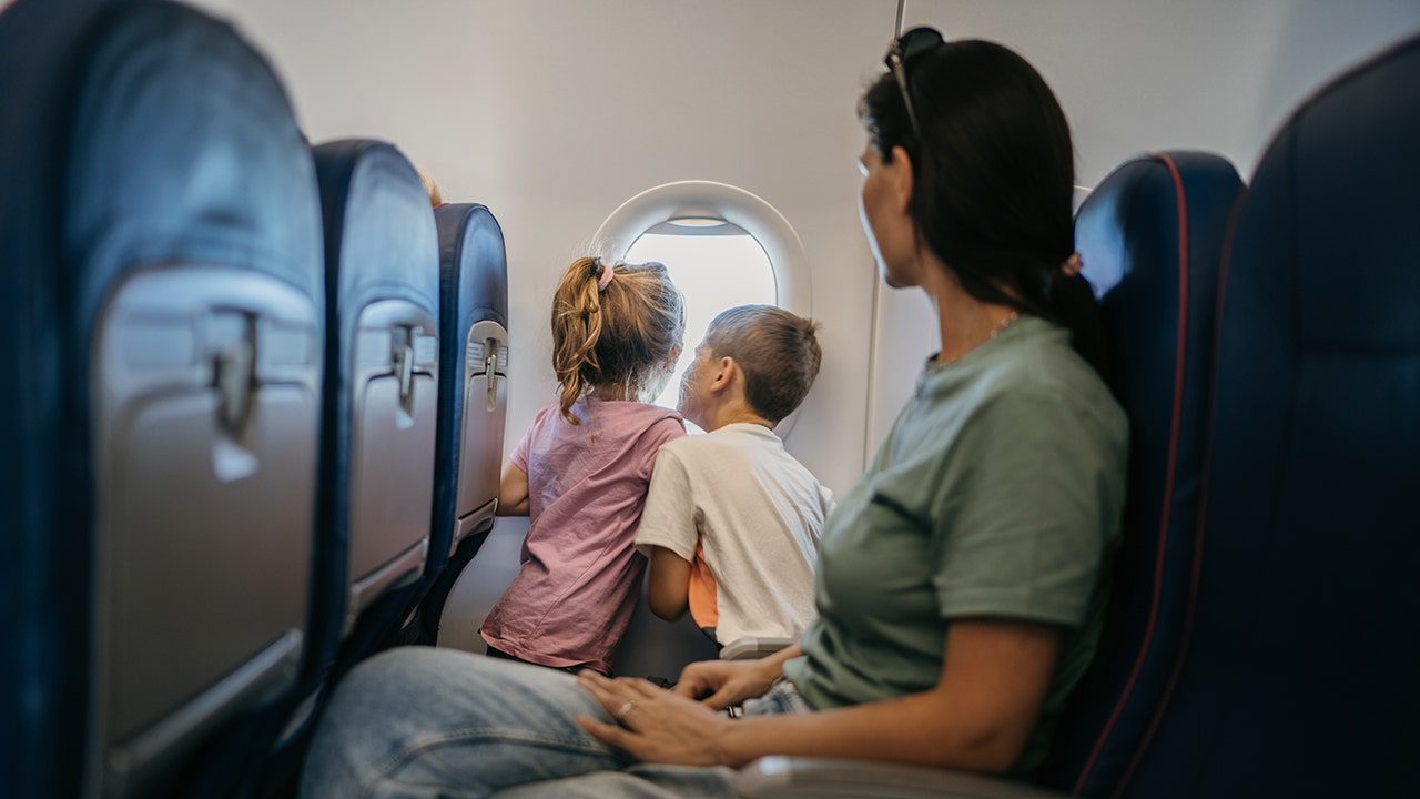 children-looking-plane-window-mother-seated.jpg