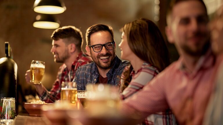 man-talking-to-woman-and-drinking-beer-at-bar.jpg