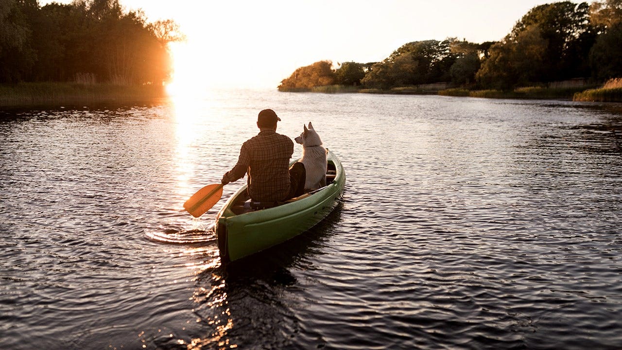 man-dog-canoeing-river-sunset.jpg
