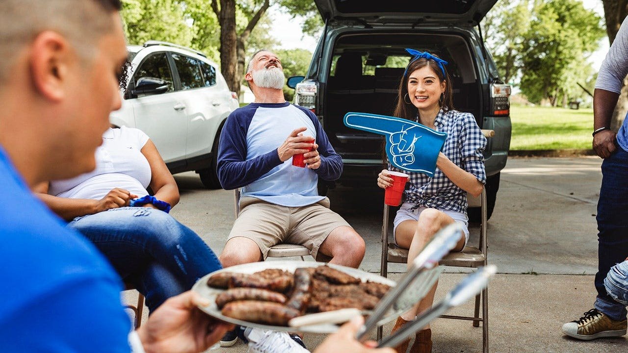 man-handing-out-burgers-tailgate-party.jpg