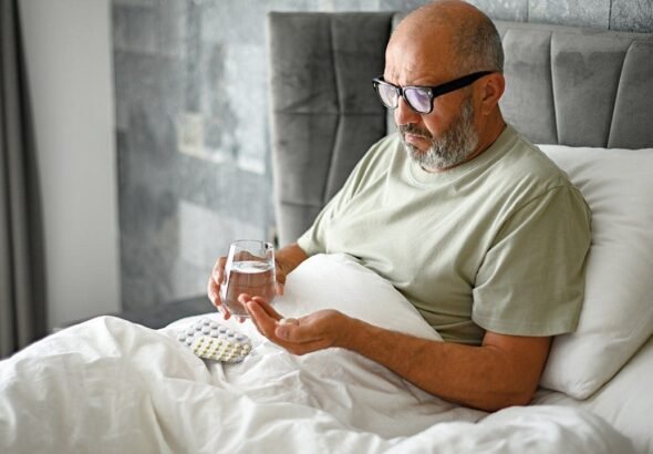man-taking-medication-bed.jpg