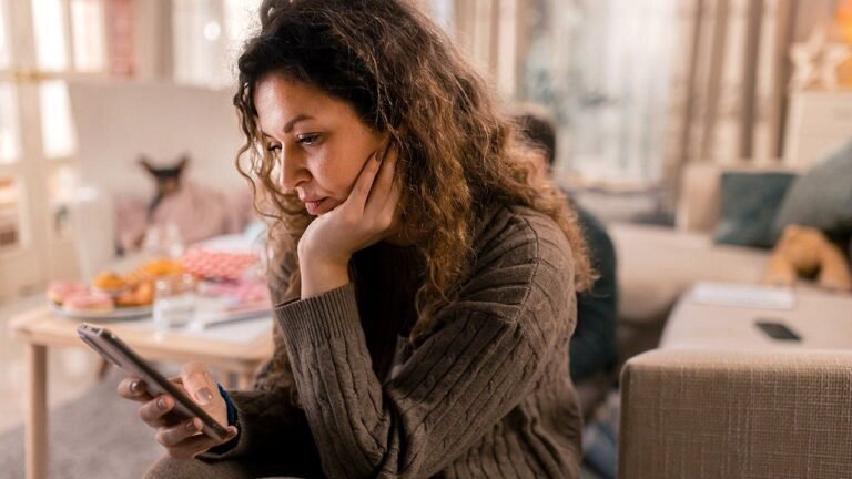 woman-worried-checking-smartphone-home.jpg